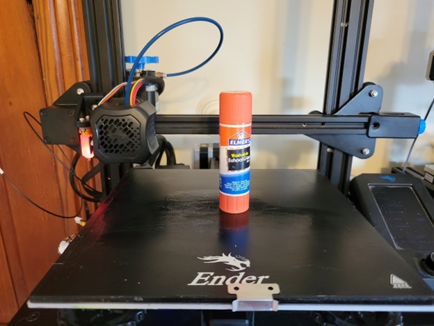 An Ender 3 V2 3D printer with a glue stick