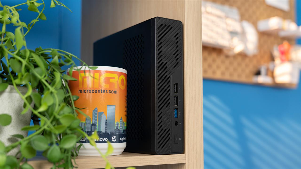 a small server on a shelf next to a plant and Micro Center mug