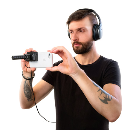 Gue in headphones using the IK Multimedia iRig Mic Video Universal digital shotgun microphone attached to a smartphone