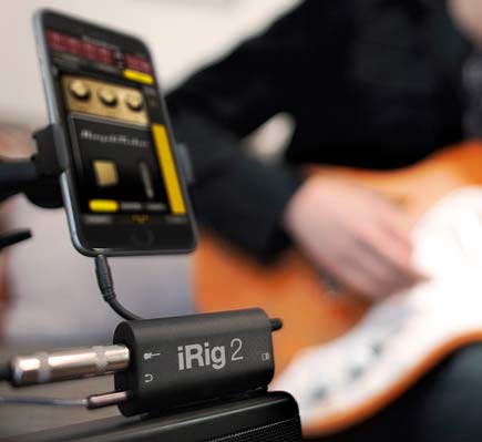 Guitar player connected to the IK Multimedia iRig 2 Mobile Guitar Interface with screen displayed