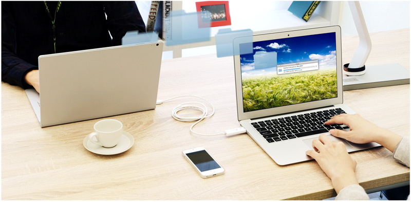 Two laptops connected via the j5create USB 2.0 Male Wormhole Switch Transfer Cable