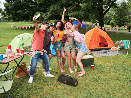 Friends dance at a campsite with JBL Boombox 2