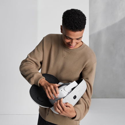 User holding open case with headset inside