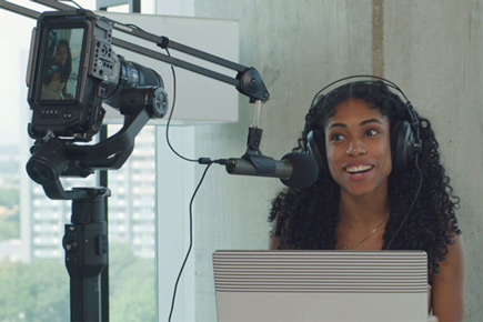 Girl speaking into Samson Q2U Microphone connected to video camera