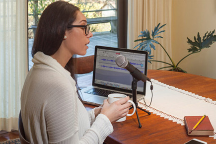 Woman speaking into Samson Q2U Microphone connected to a laptop