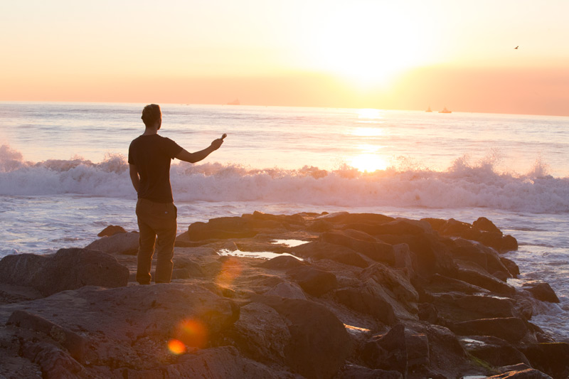 Guy at the beach capturing the sound of the waves