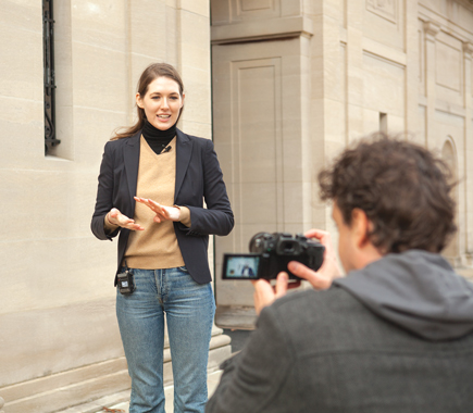 Zoom F1 Field Digital Recorder with LMF-1 Lavalier mic being used to record an on-street interview with a professional woman in front of a building