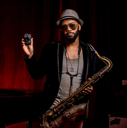 Saxaphone player on stage holding the The Zoom Q2n-4K video recorder