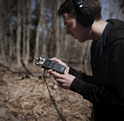 Hiker using the Zoom H5 Handy Recorder to record nature sounds