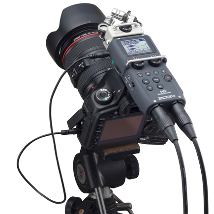 Close up top view of the Zoom H5 Handy Recorder with cabels attached to a camera on a tripod