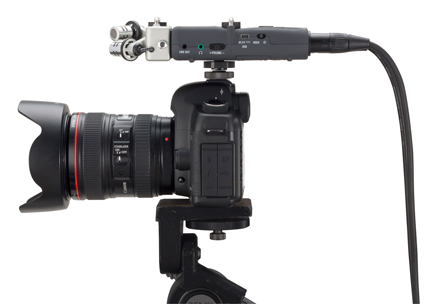 Close up side view and ports of the Zoom H5 Handy Recorder with cabels attached to a camera on a tripod