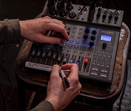 Close up of a guy making notes on the Zoom LiveTrak L-8 Portable 8-Channel Digital Mixer and Multitrack Recorder