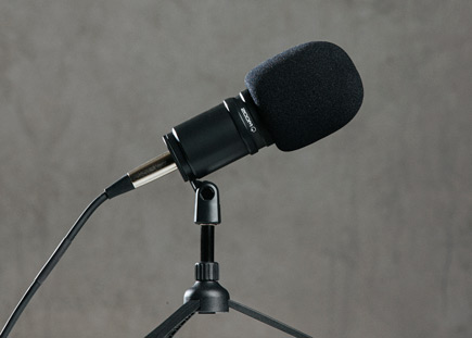 Close up of the the Zoom ZDM-1 Podcast Mic Pack microphone on a table top tripod