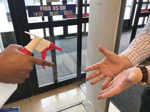 greeter spraying sanitizer