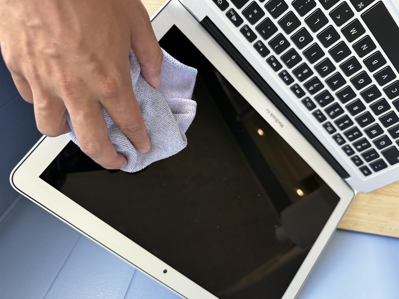 a macbook screen being wiped down