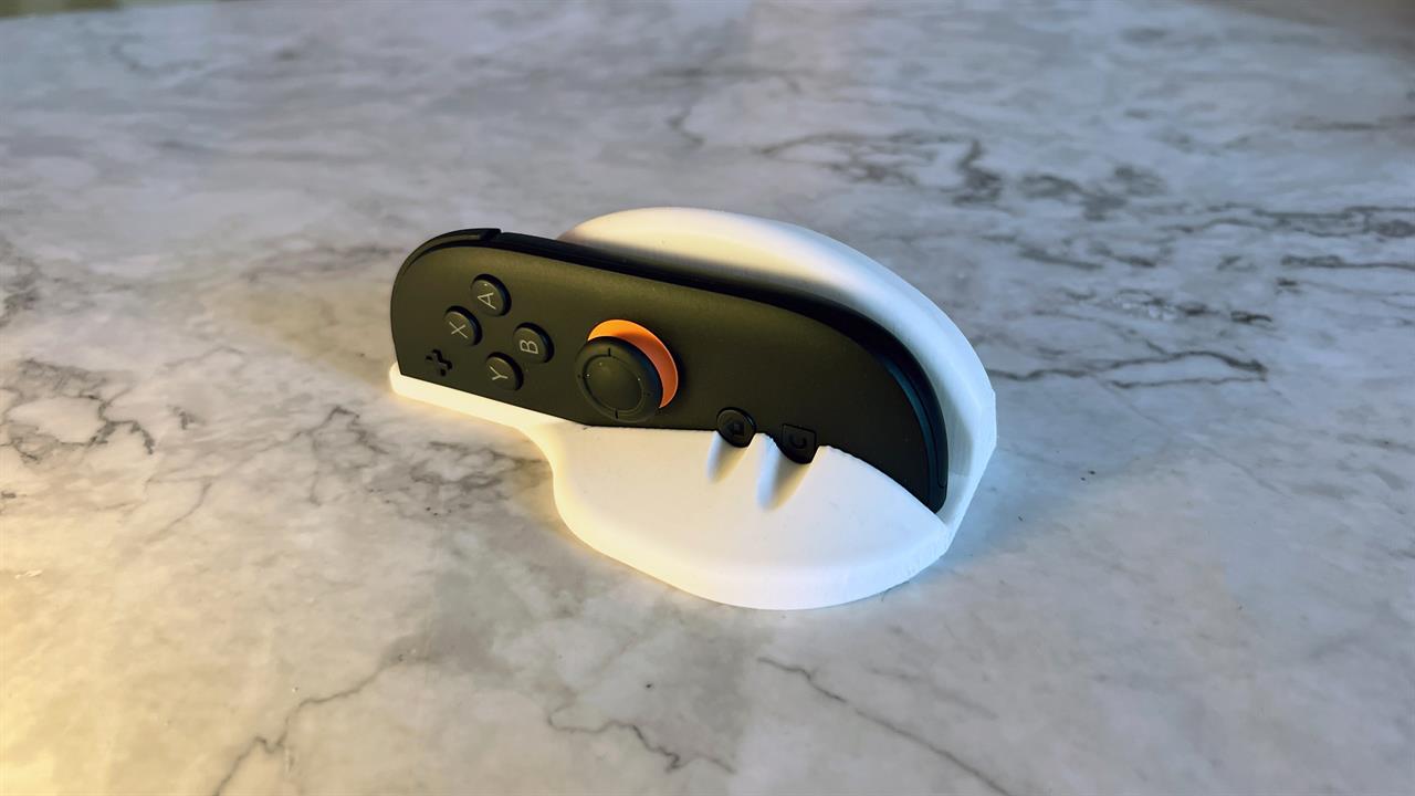 A switch 2 joycon in a 3d printed mouse mode dock
