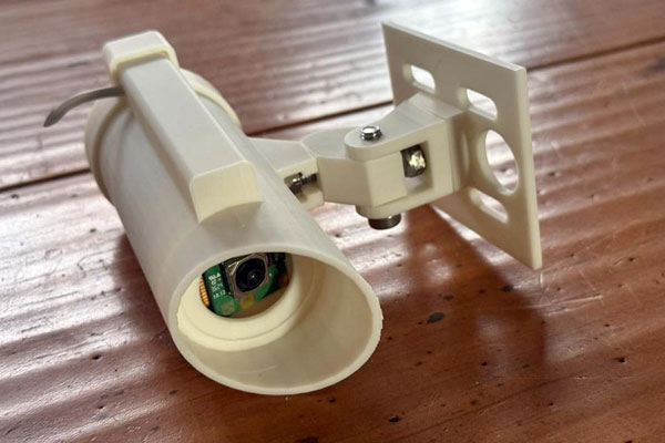 Picture of a security camera built off Raspberry Pi on a wooden table
